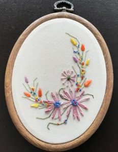 colorful embroidery on an oval canvas